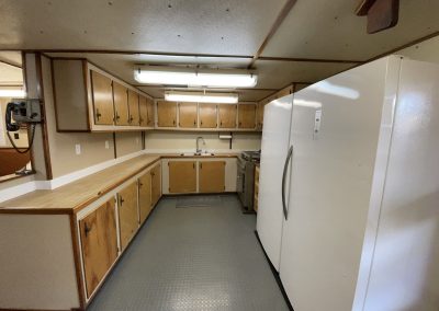 Interior view of the fully equipped crew galley inside the R/V Peter M Mahoney, featuring wooden cabinetry, expansive countertops, and standard appliances.
